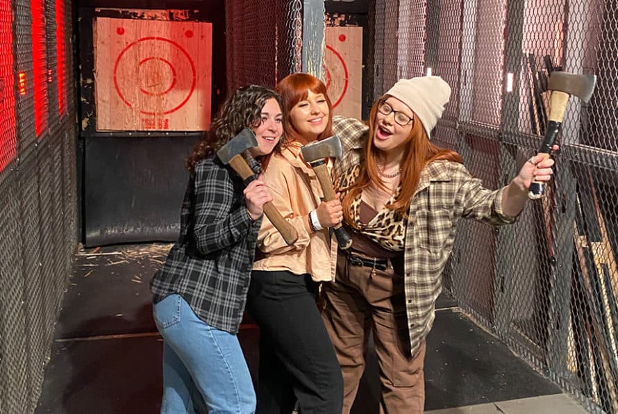 3 women posing with throwing axes