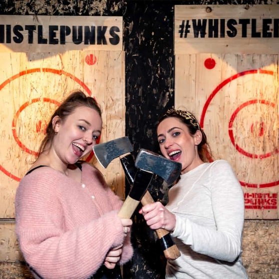2 women posing with throwing axes crossed