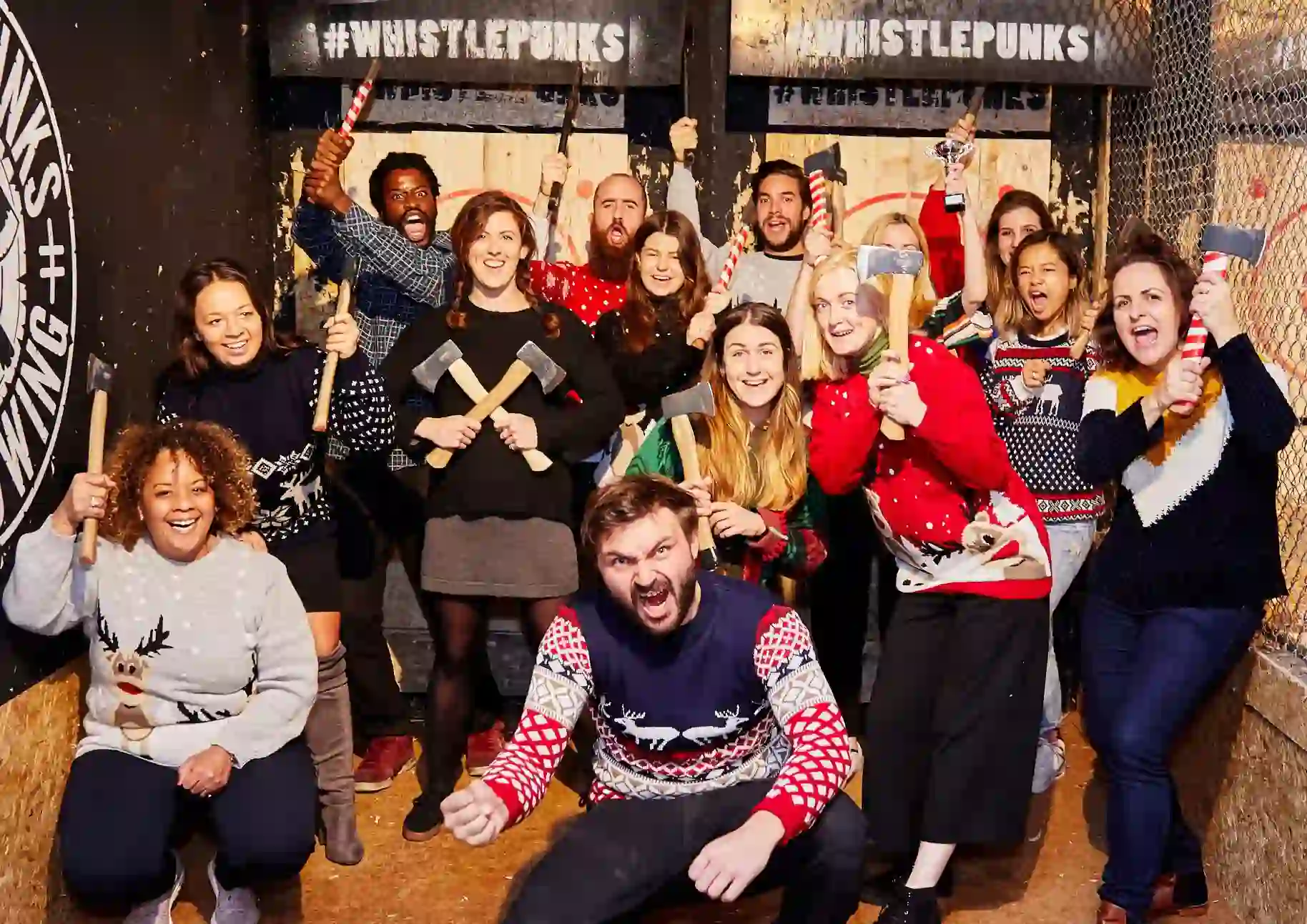 group in Christmas jumpers posing with axes