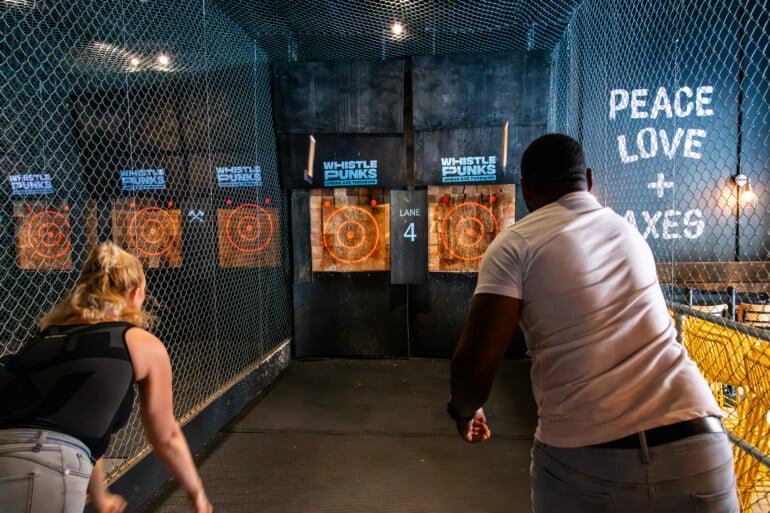 man and woman throwing axes at whistlepunks