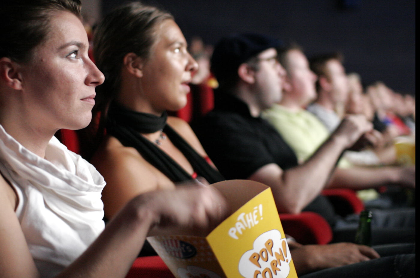people watching film at the cinema eating popcorn